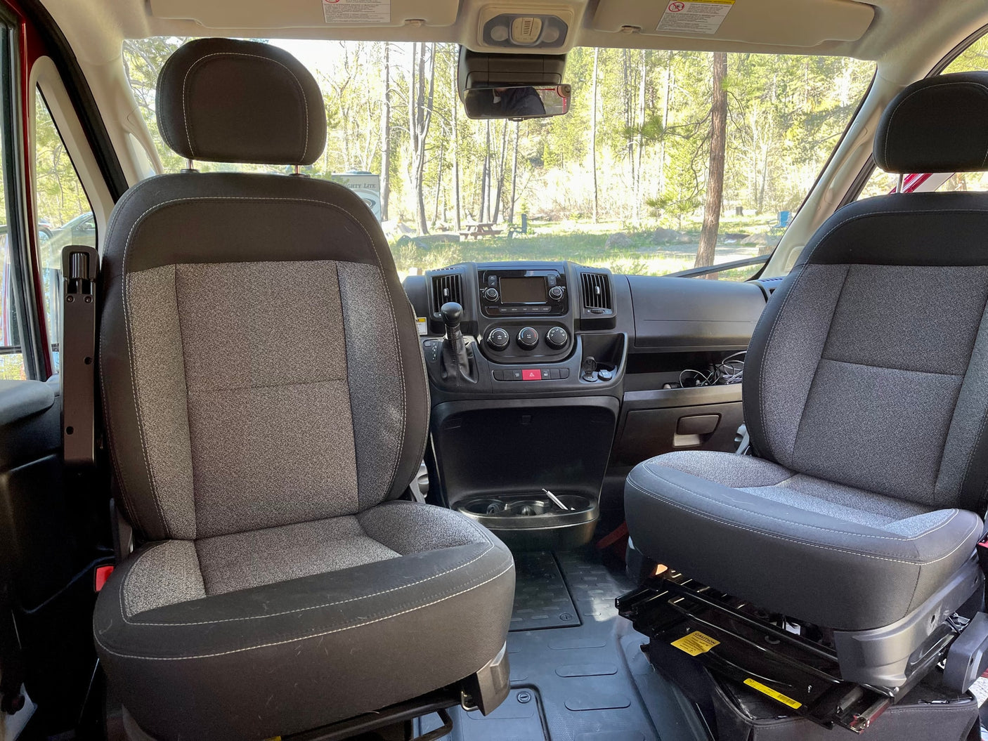 open van door reveals a serene river and forest.|Step inside this compact RV rental