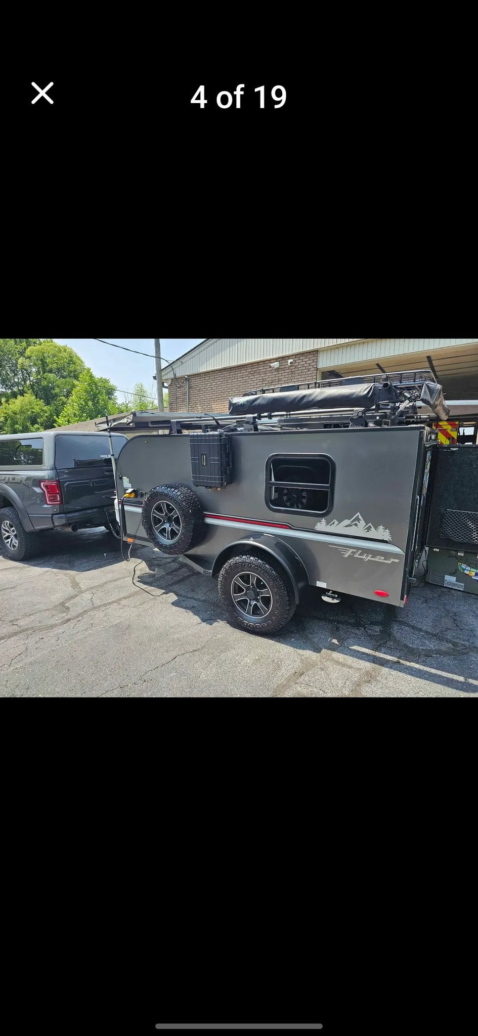 Gray pickup truck towing a rugged off-road teardrop camper. Ideal RV rental for your next outdoor adventure.