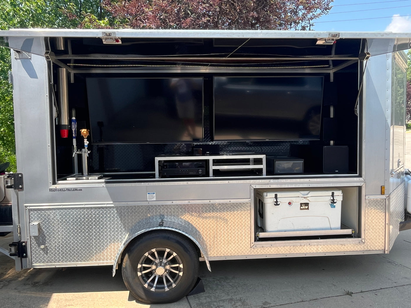 This custom **rv rental** event trailer brings entertainment outdoors, featuring dual TVs, beer taps, and a pull-out cooler. — photo 2