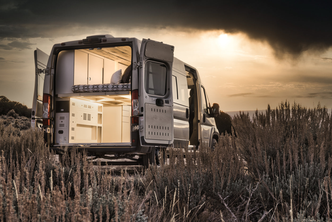 Explore with this RV rental camper van, revealing its custom interior with open doors.
