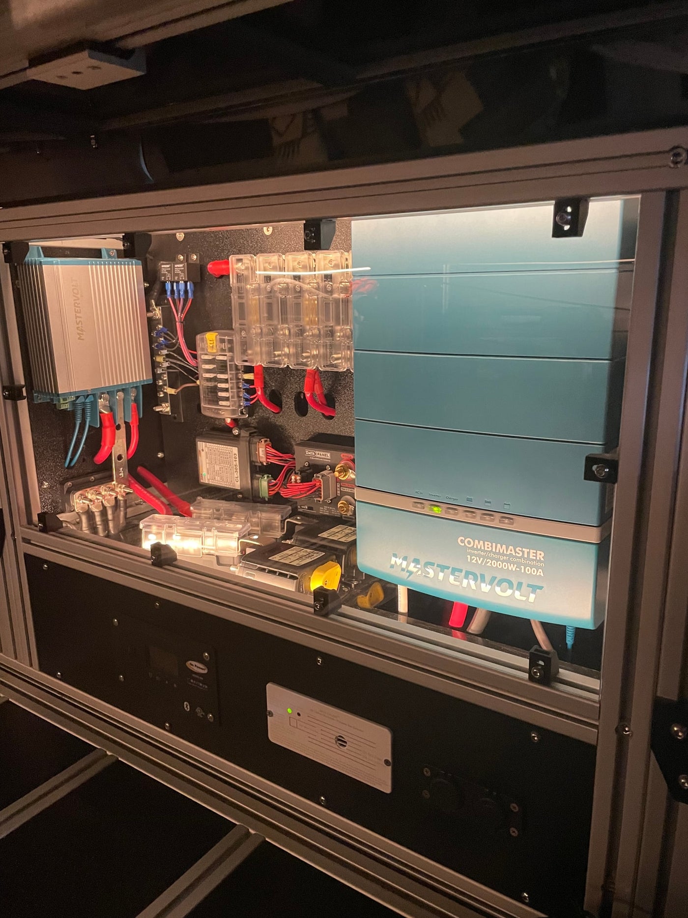 Advanced Mastervolt power system in an RV rental, showing a CombiMaster inverter/charger, multiple fuses, and wiring for efficient power management. — photo 16
