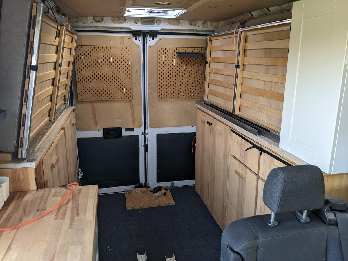 and portable toilet for comfortable living.|This RV rental offers a custom-built camper van interior featuring a wooden kitchen — photo 4