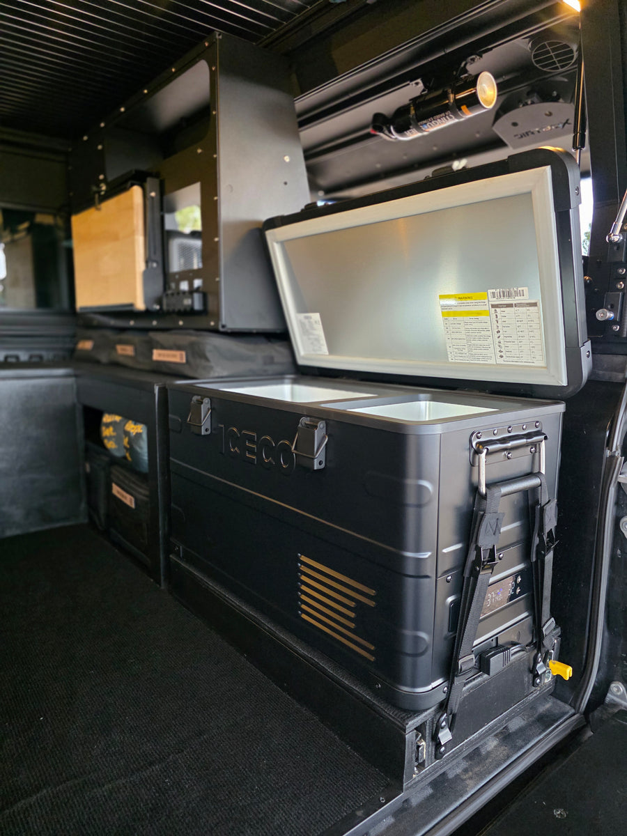 This RV rental's organized interior features an ICECO fridge/freezer, modular storage, and a safety extinguisher.