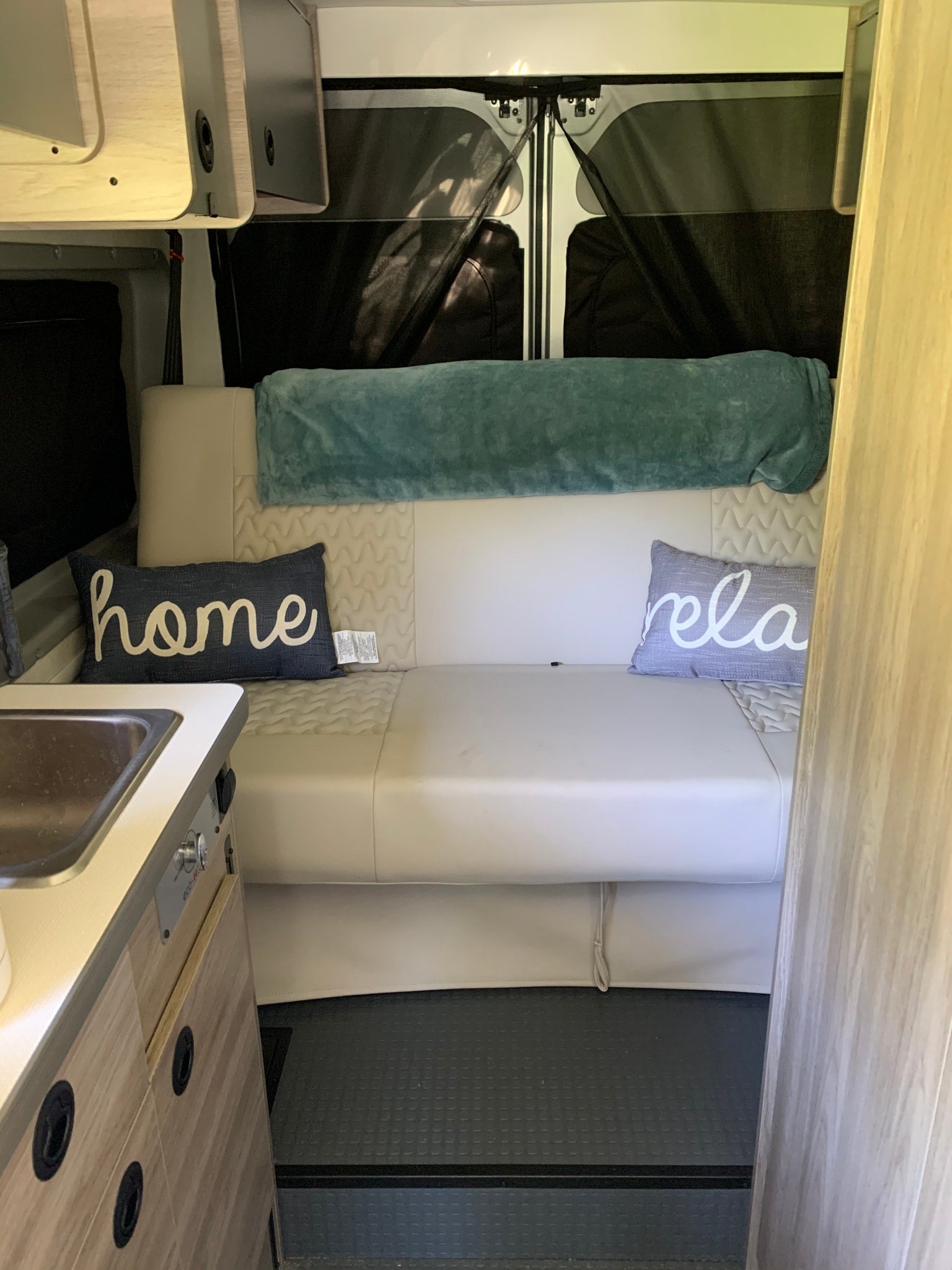 showing its wire shelves and door storage.|RV rental under-counter storage: Lys Lysol cleaner