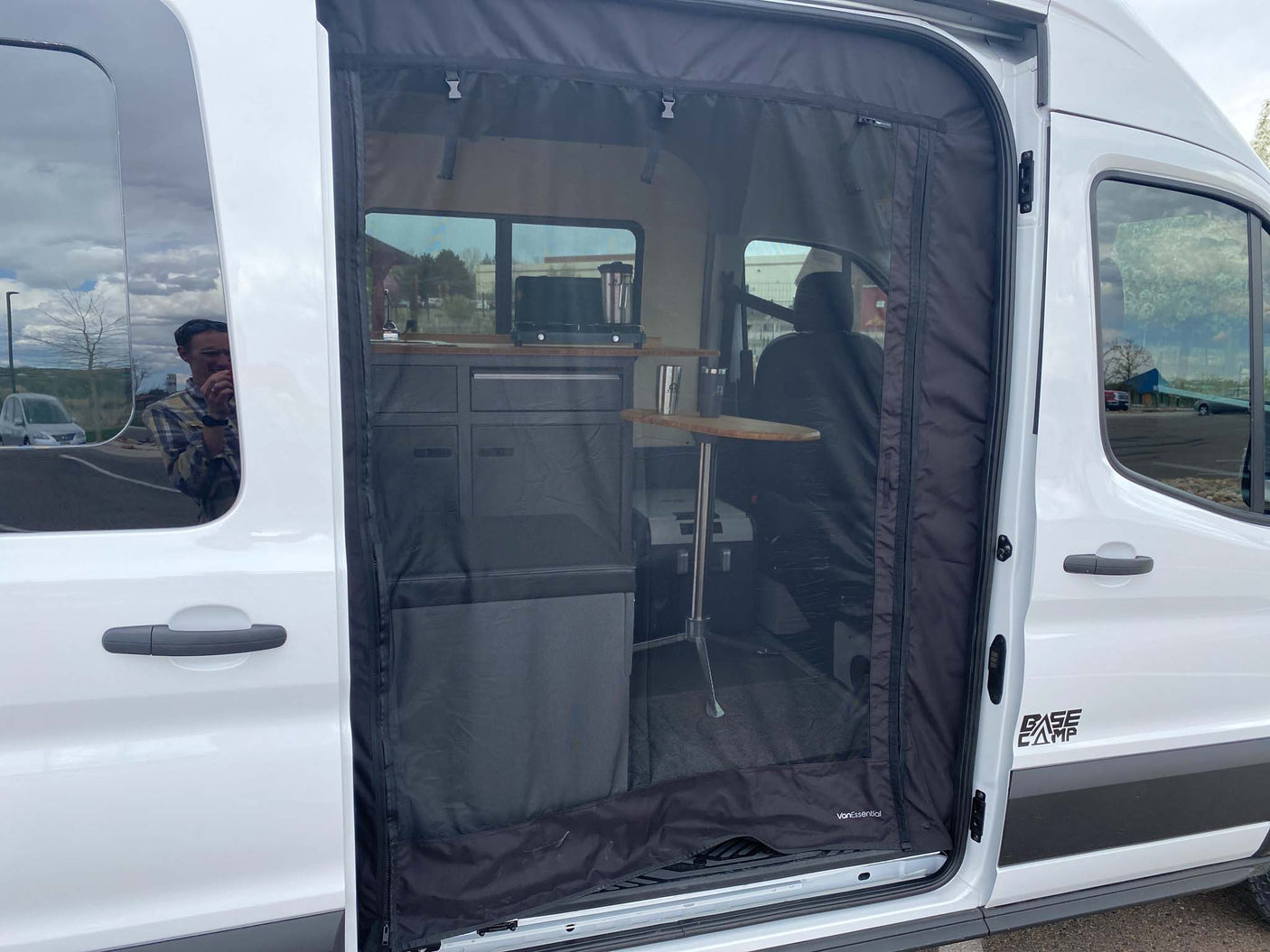 Inside an rv rental camper van: screen door open, revealing a compact kitchen and seating. Perfect for van life travel!