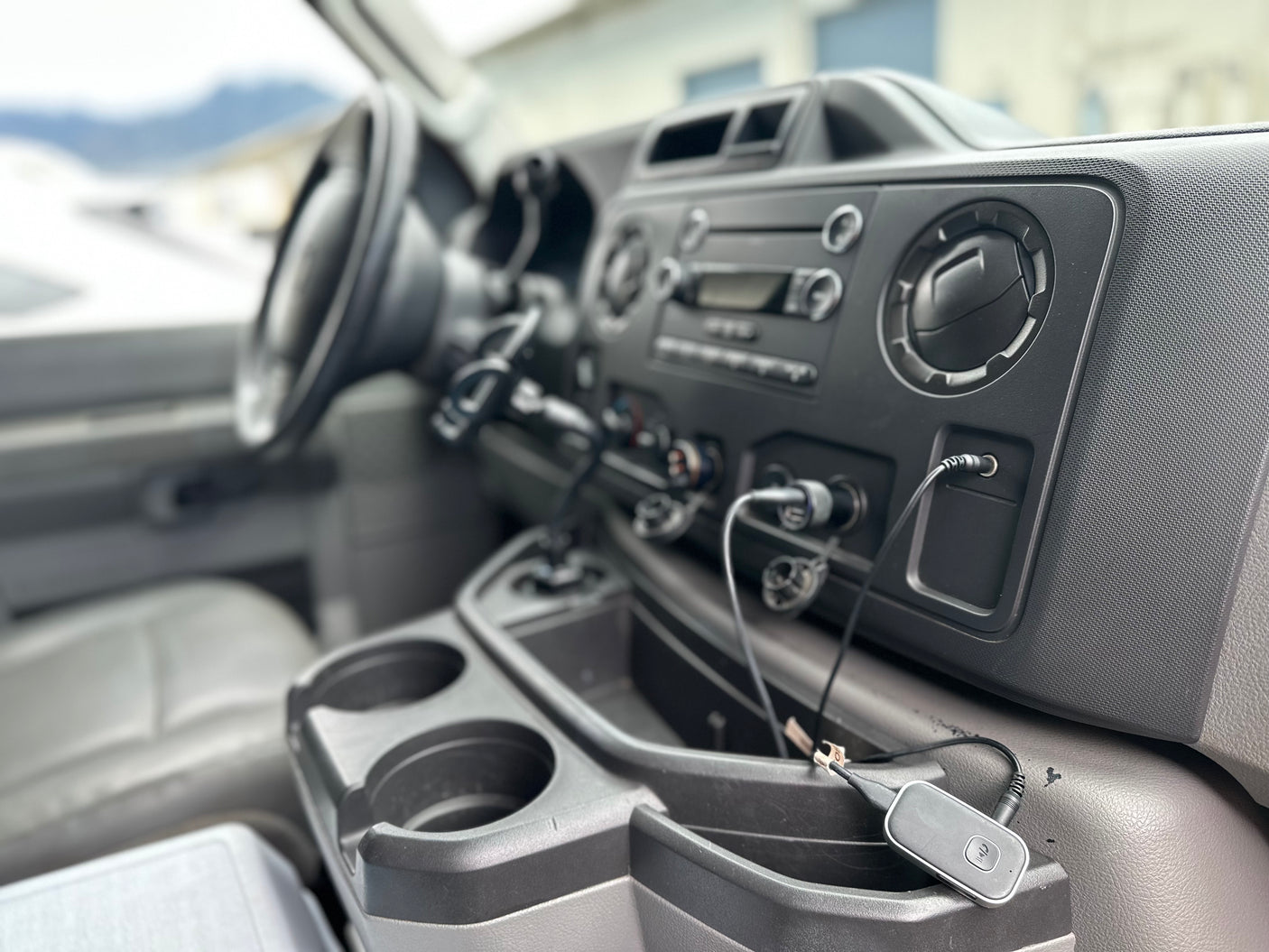 Inside an RV rental: detailed view of the dashboard, console, and tech accessories, perfect for your road trip.