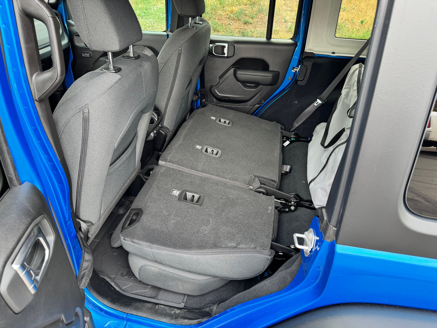 Interior of blue vehicle, rear seats folded flat. Spacious cargo area for an RV rental or adventure trip.