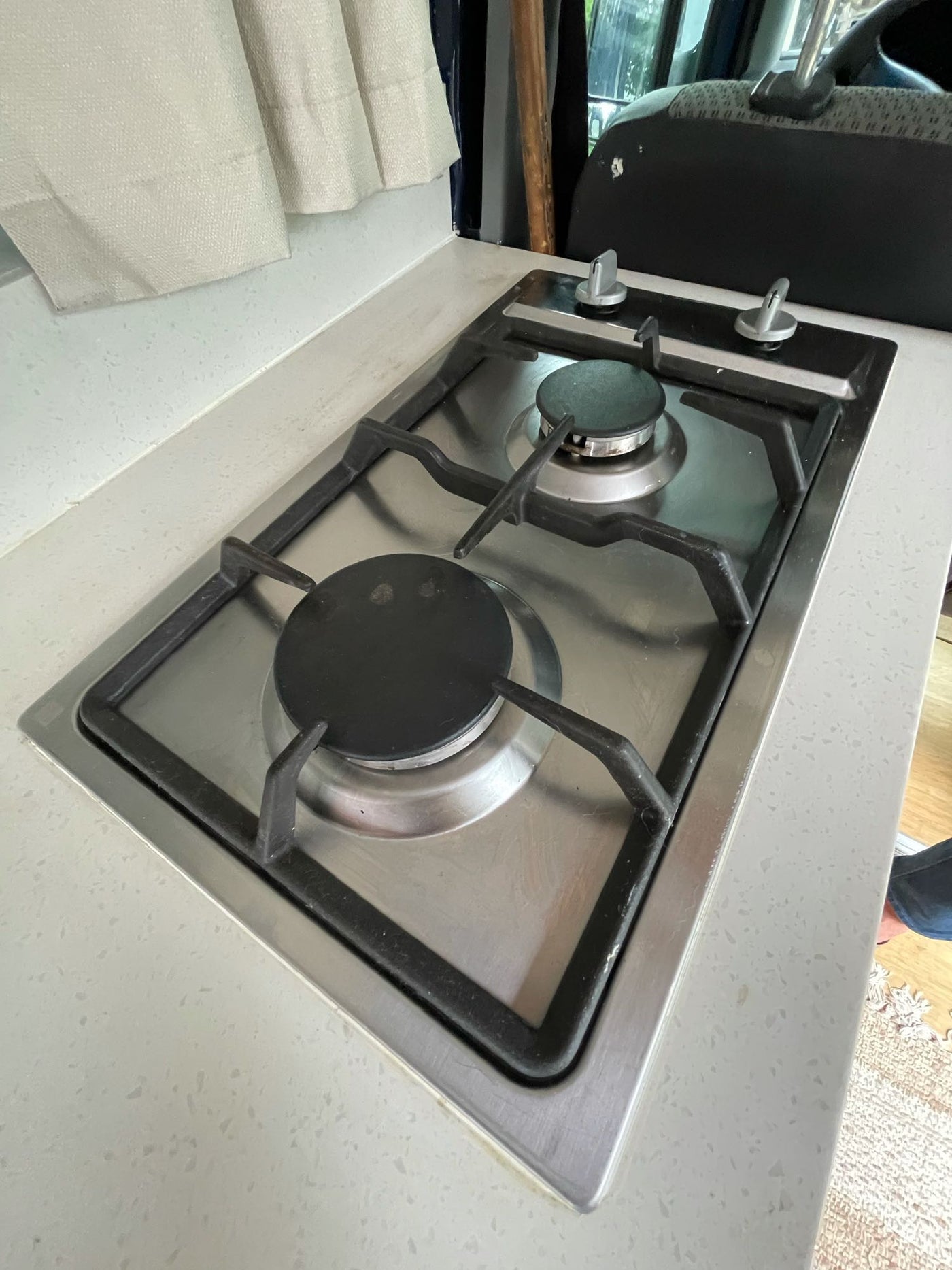 Modern stainless steel two-burner gas cooktop in an RV rental kitchen, ideal for on-the-go cooking, set in a light counter. — photo 10