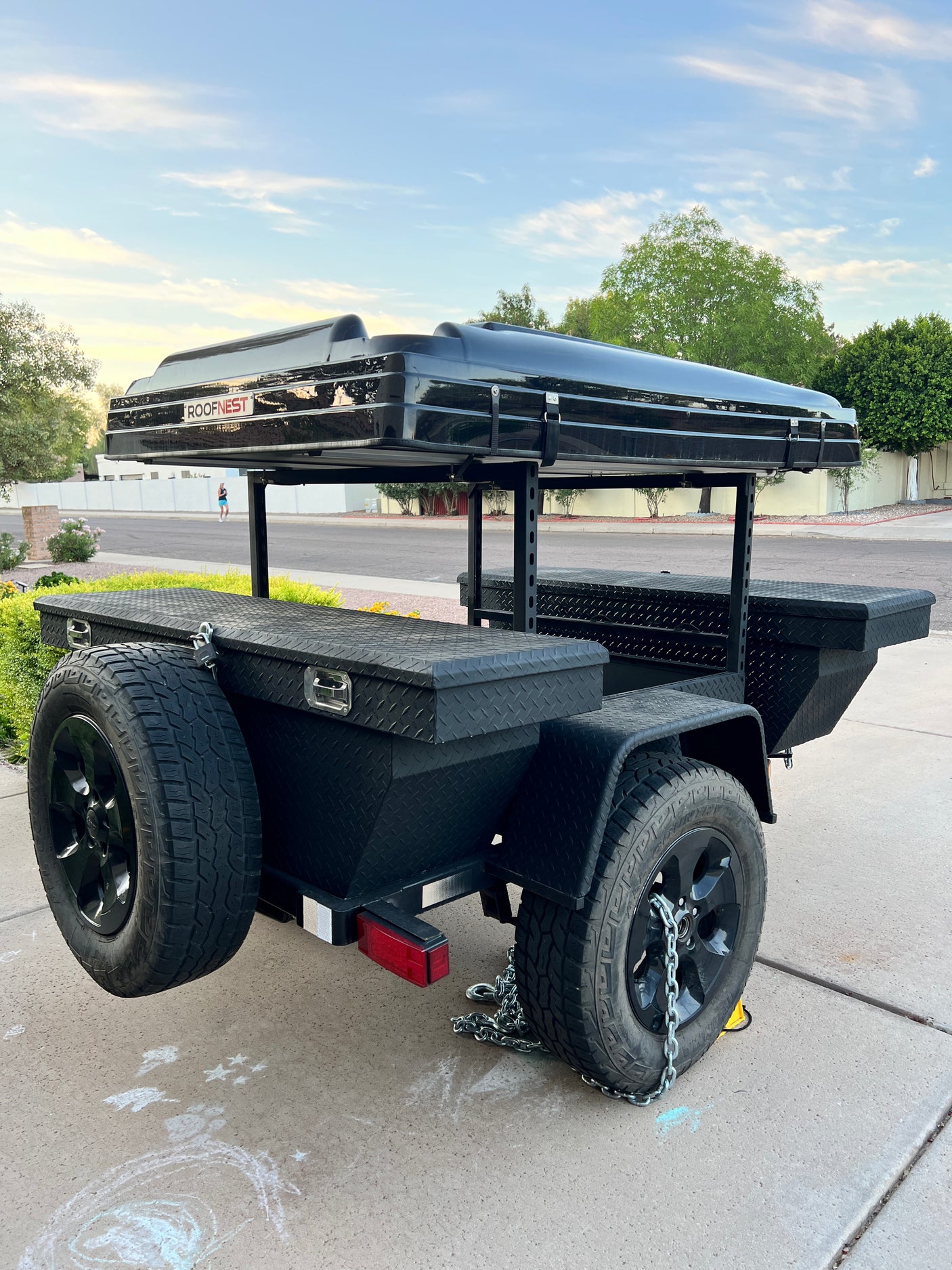This black camping trailer with a rooftop tent is perfect for your next RV rental adventure. Features durable off-road tires and storage.