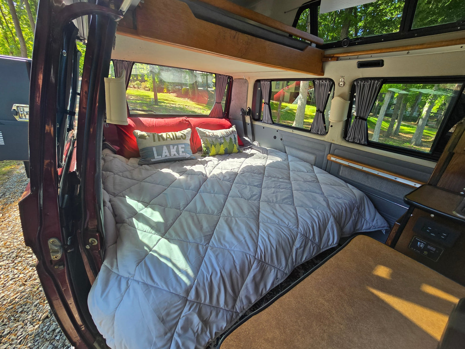 offering a peaceful lake view for your next adventure.|Step inside this RV rental! Cozy camper van interior with a seating area