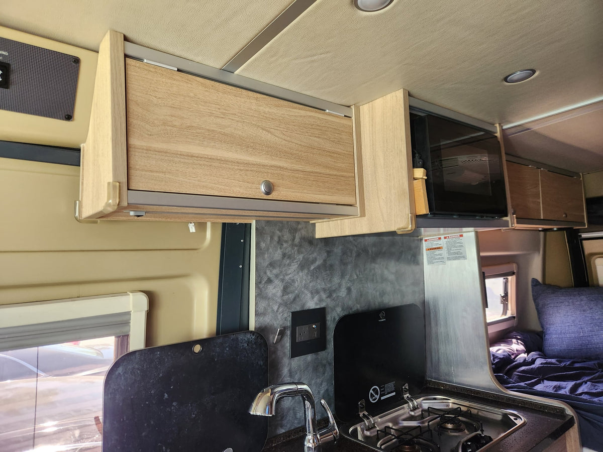 and wood-look finishes.|Cozy RV rental interior with a compact bed — photo 9