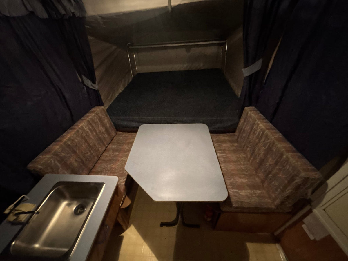 retro RV rental offers king-size beds.|This vibrant Laredo RV rental pop-up camper with Starlink Wi-Fi glows turquoise at night — photo 10
