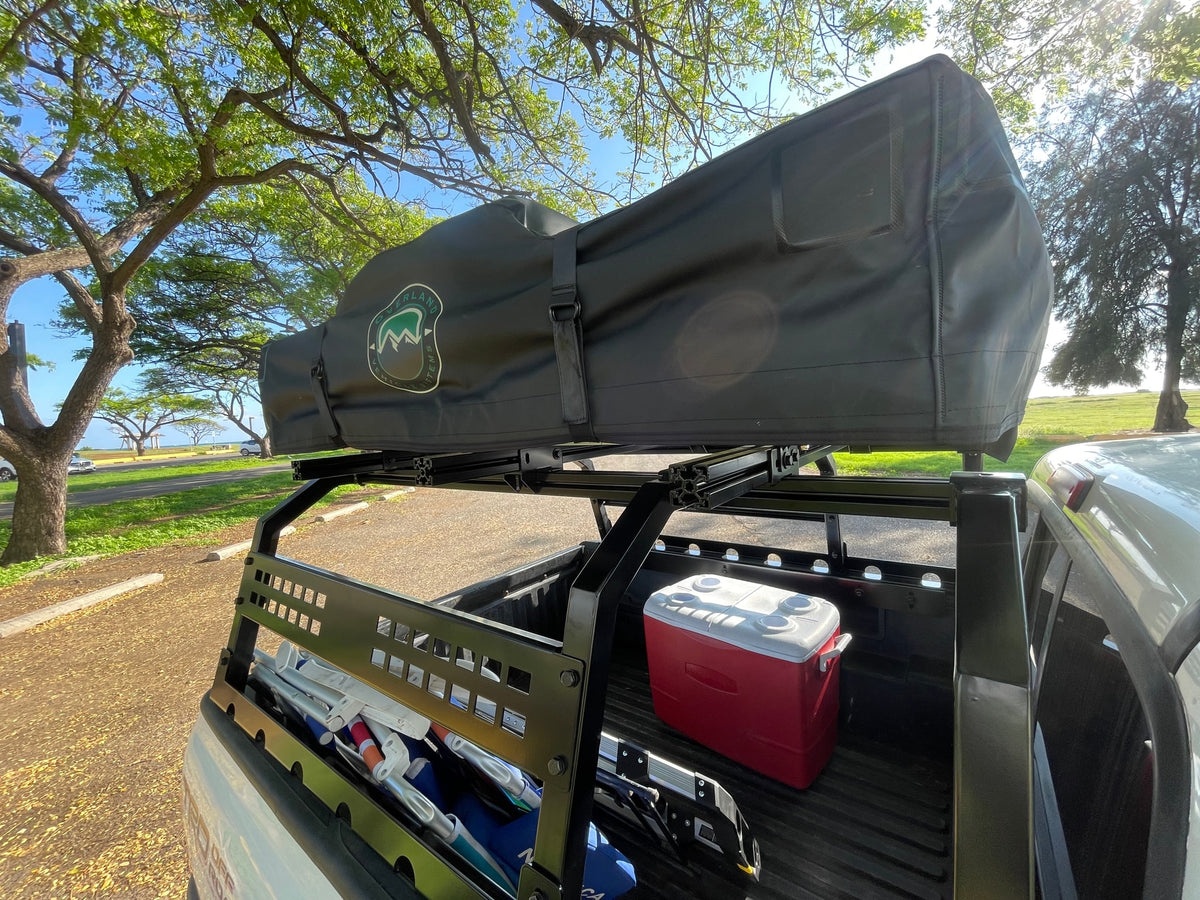 A pickup truck with a black rooftop tent on a bed rack, cooler, and gear, perfect for an RV rental camping trip. — photo 6