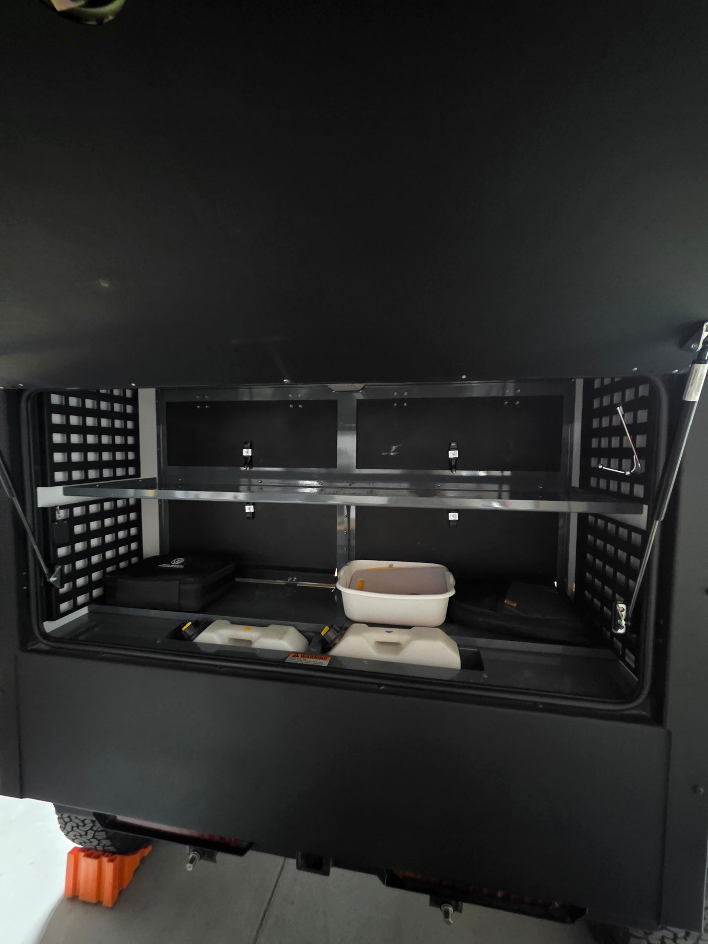 Ample storage in this RV rental's organized rear compartment, featuring shelves & bins for adventure essentials.