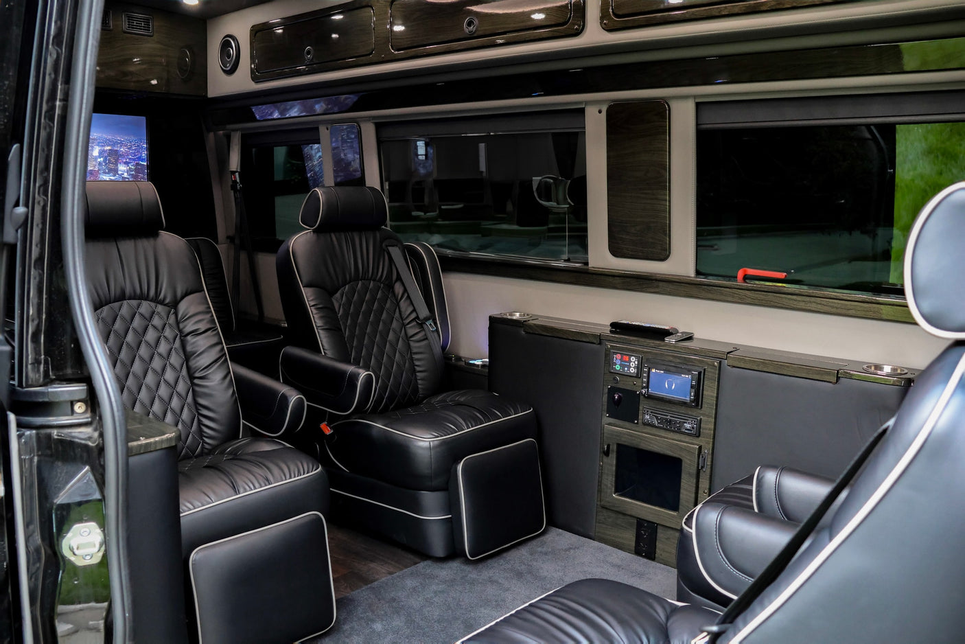 Step inside this luxury rv rental, featuring plush black leather captain's chairs and an entertainment system for comfortable travel.