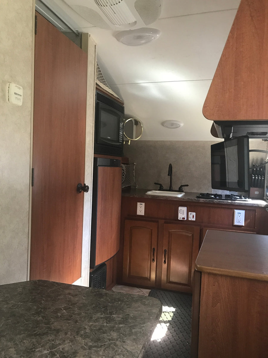 featuring colorful ring decals on its side.|Cozy dinette inside an RV rental