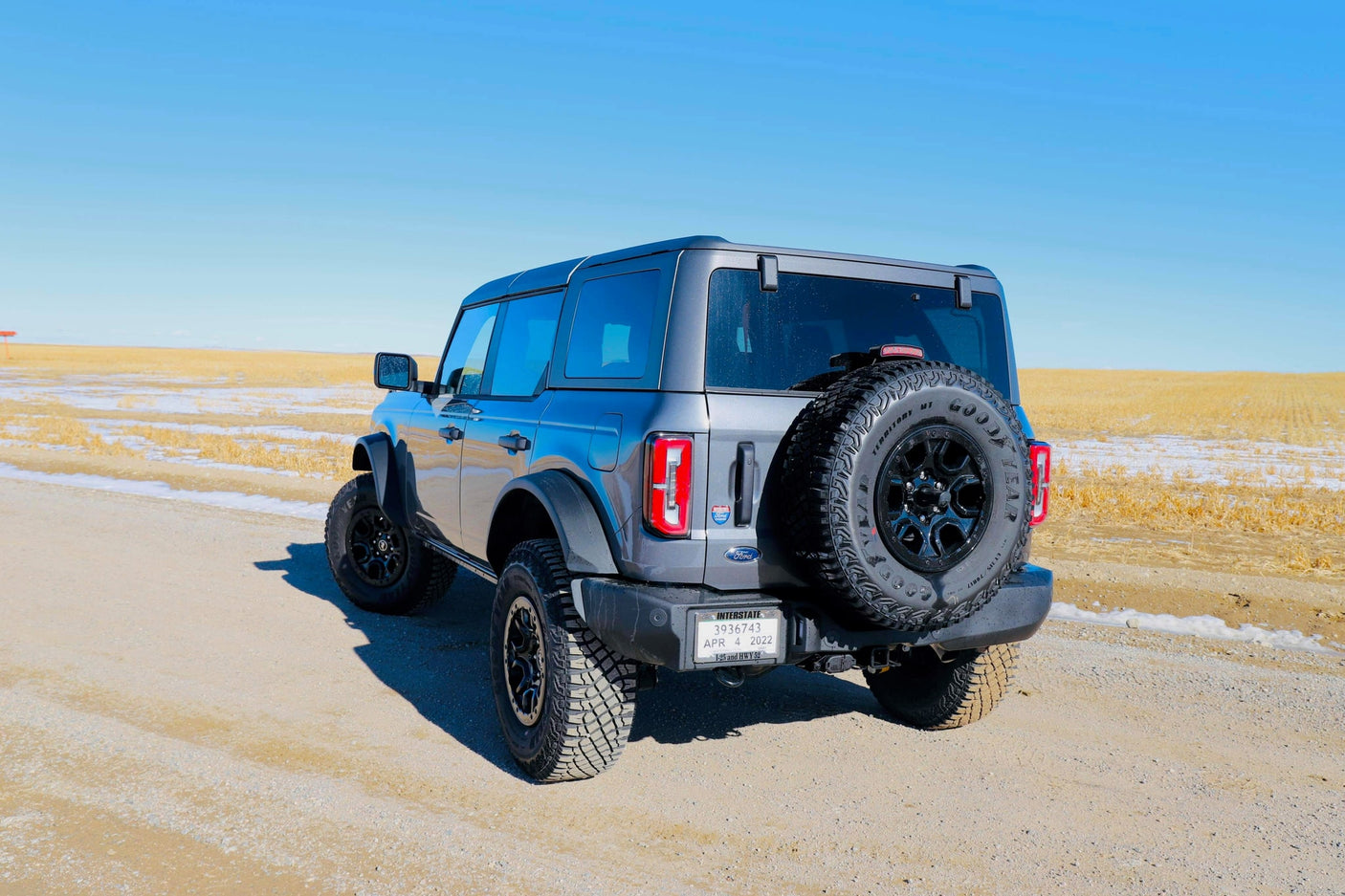 A gray Ford Bronco SUV on a dirt road, ready for off-road adventure under clear skies. A rugged alternative to an rv rental for exploring.