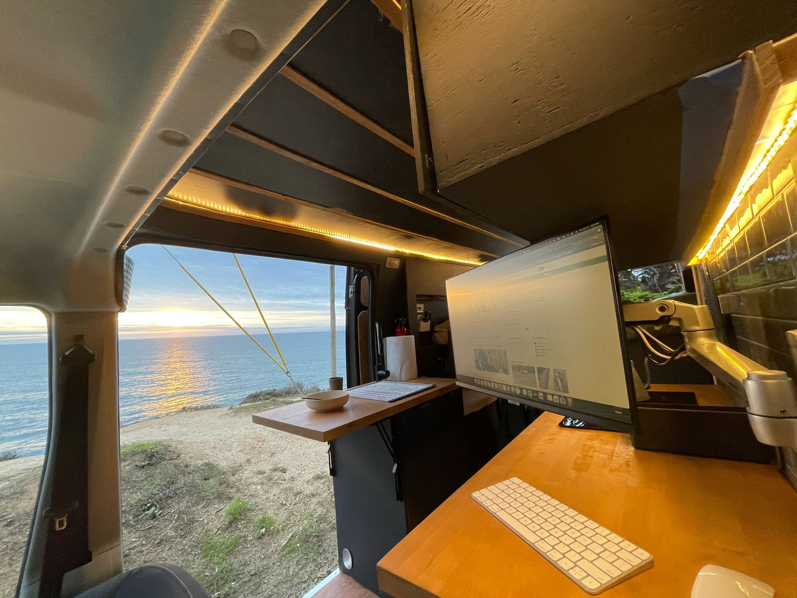 and mugs offers a peaceful ocean view from a coastal setting.|RV rental interior: A compact setup featuring a mounted air compressor