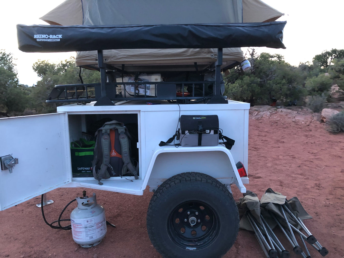 An off-road camping trailer, like an RV rental, with rooftop tent, accessible gear storage, propane, and Goal Zero power for adventures.