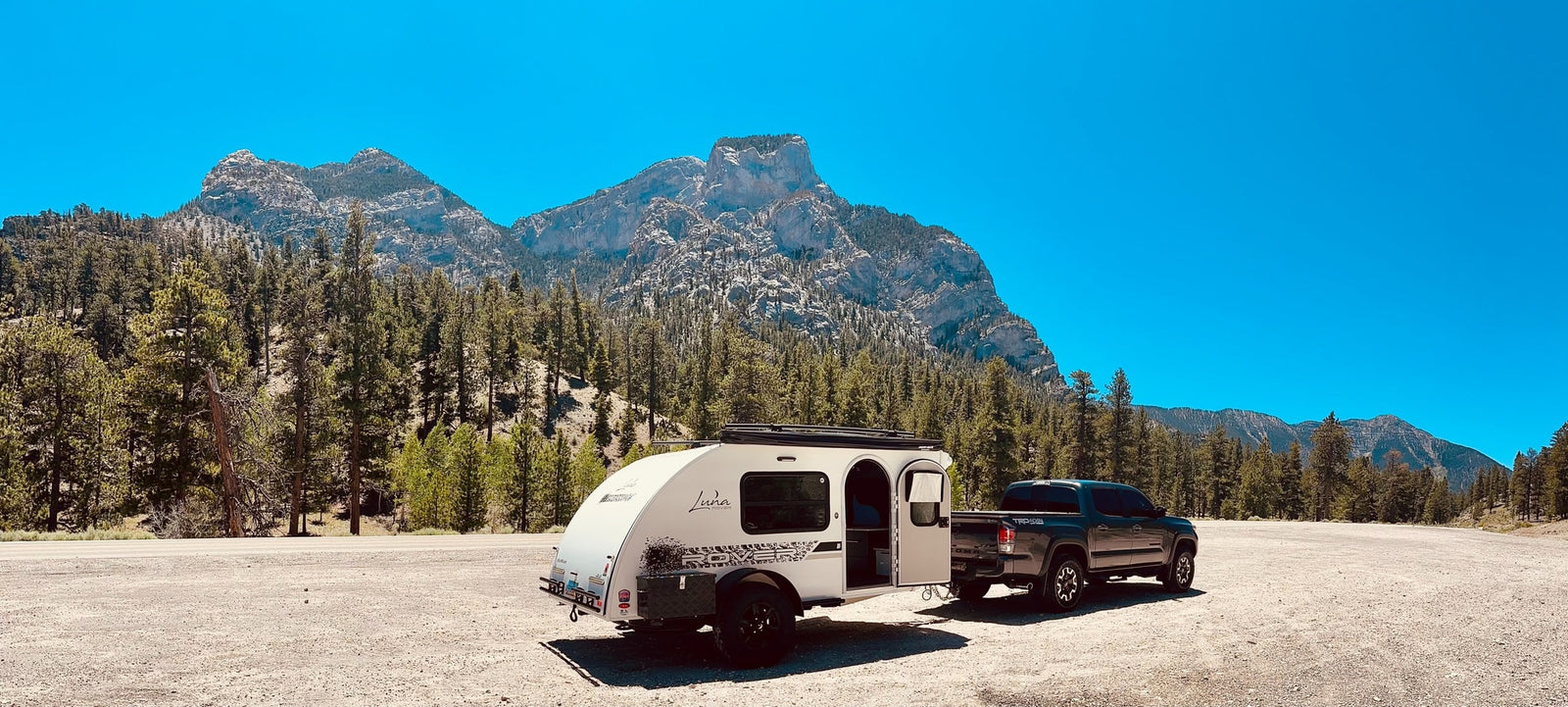 A Tacoma truck tows a compact teardrop RV rental