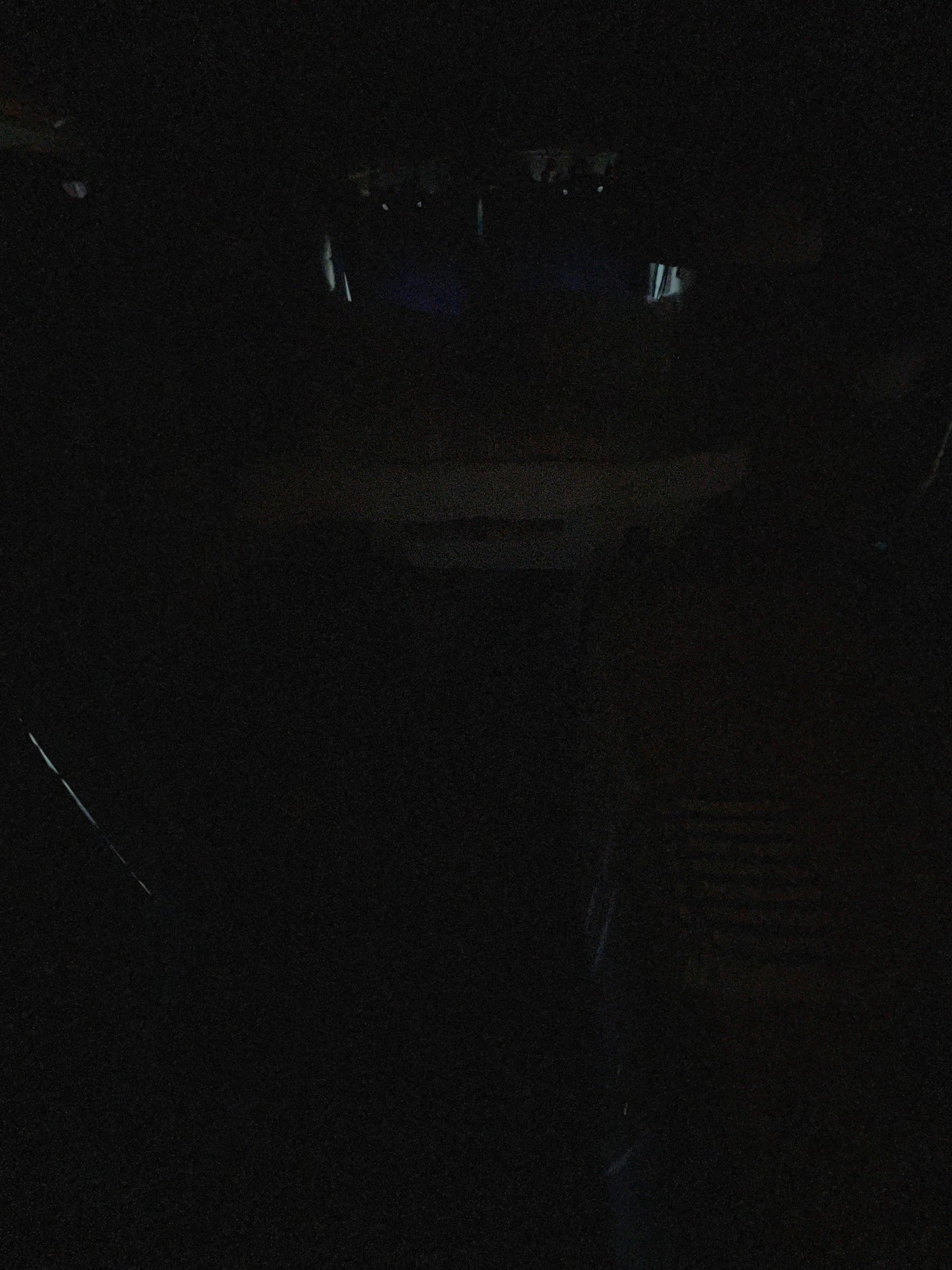 Extremely dark RV rental interior at night, with only faint outlines of the cabin visible.