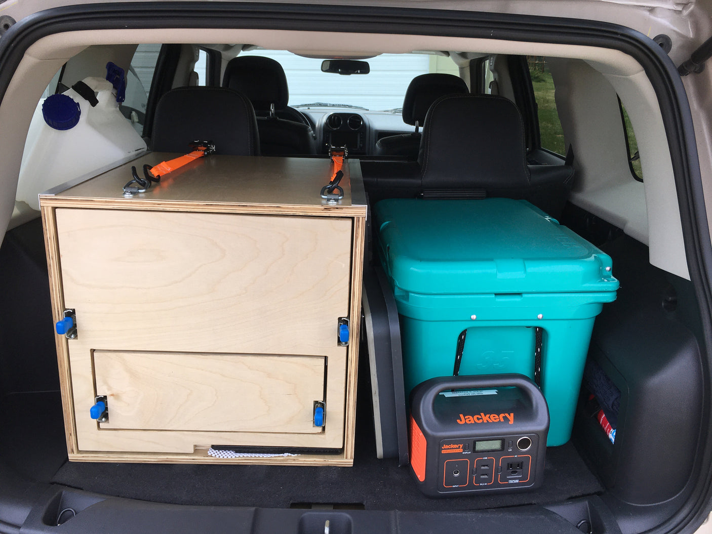 SUV car camping setup: custom storage, water, cooler, Jackery power. Great for road trips, an RV rental adventure.