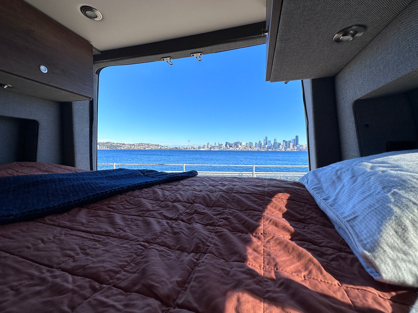 Wake up to stunning Seattle waterfront views from your cozy RV rental bed. Perfect for scenic travel!