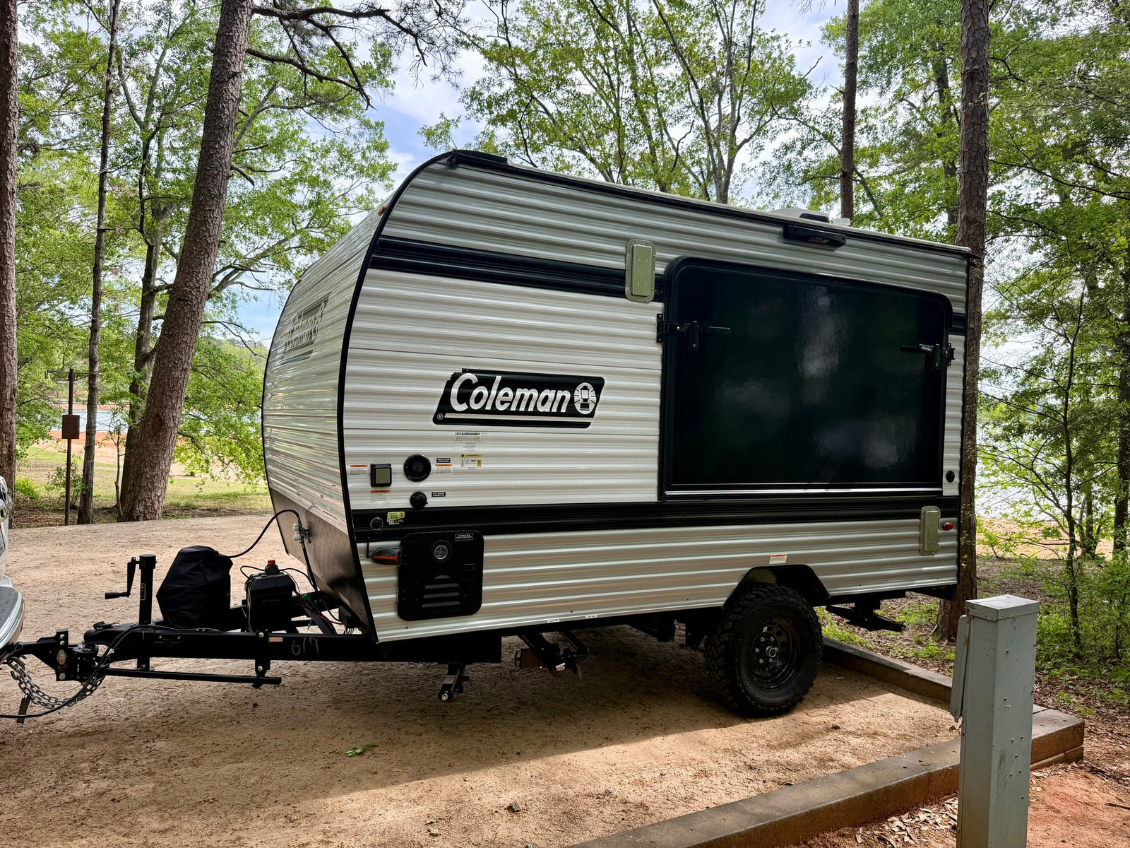 is parked at a scenic wooded campsite next to a lake