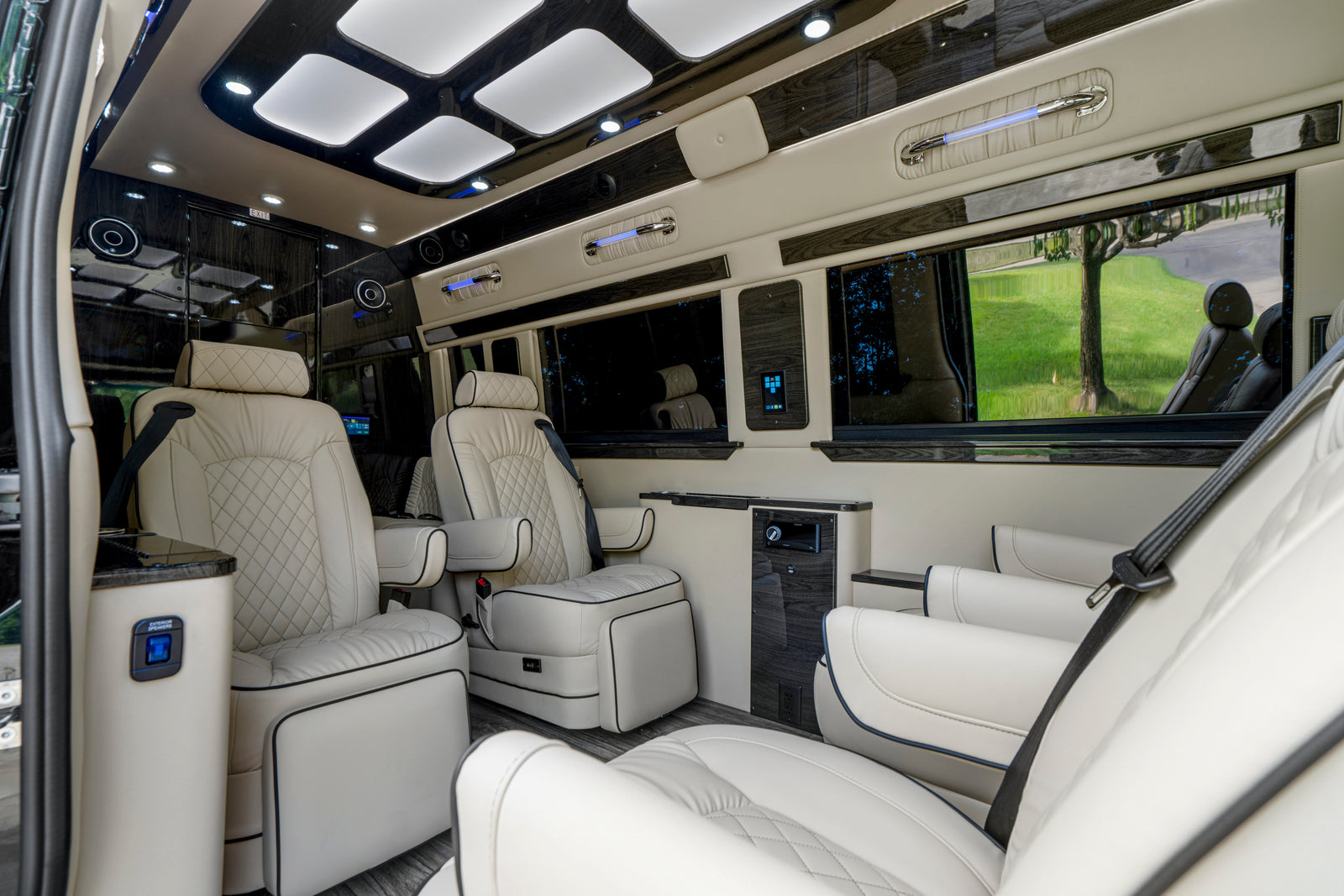 High-end **rv rental** interior, showcasing plush white leather seating, ambient lighting, and integrated entertainment system.
