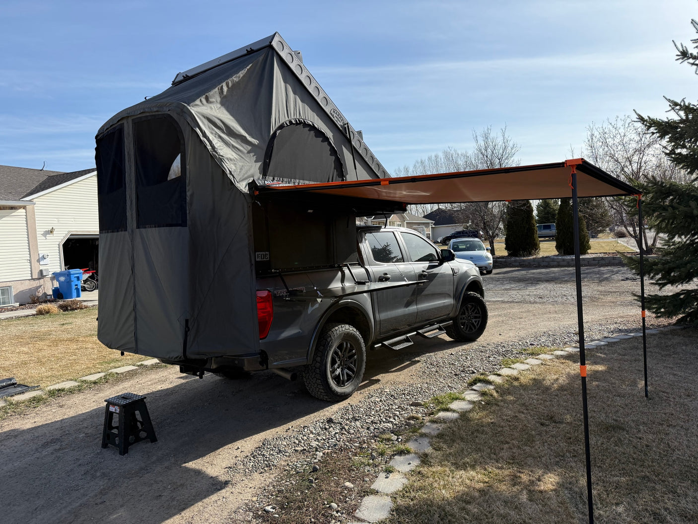 Explore with ease! A grey pickup truck featuring a spacious rooftop tent & awning for ultimate truck camping. Better than RV rental!