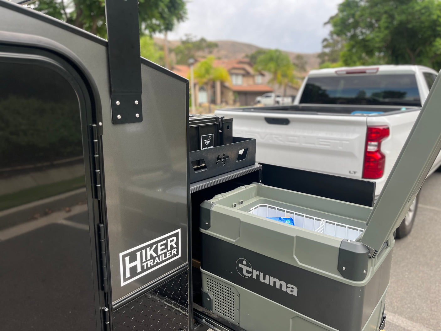 This Hiker Trailer RV rental features an accessible Truma cooler, perfect for any outdoor adventure or camping trip.