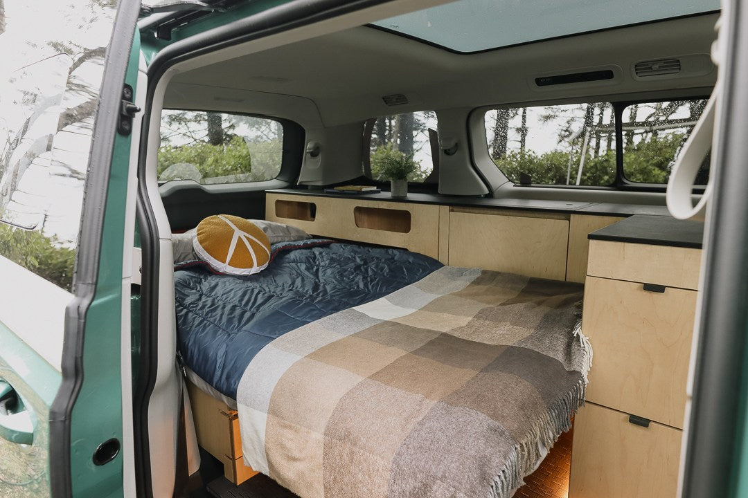 Cozy RV rental camper van interior. A comfy bed