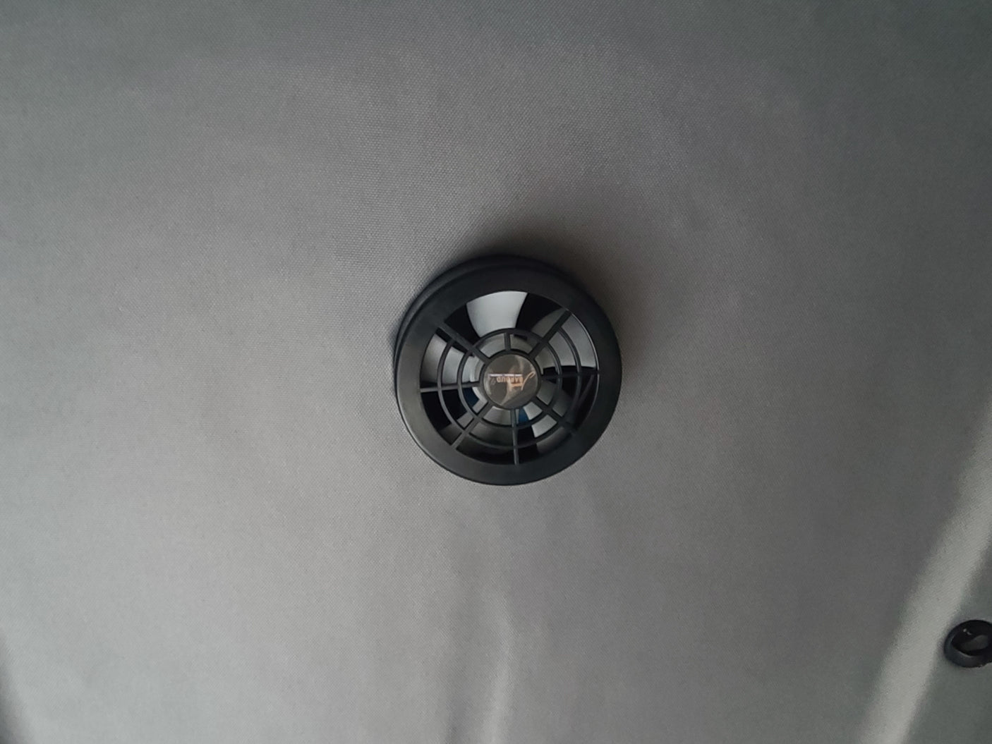 Essential for your rv rental: a ceiling-mounted ventilation fan. Features a black vent cover on a light gray fabric headliner.