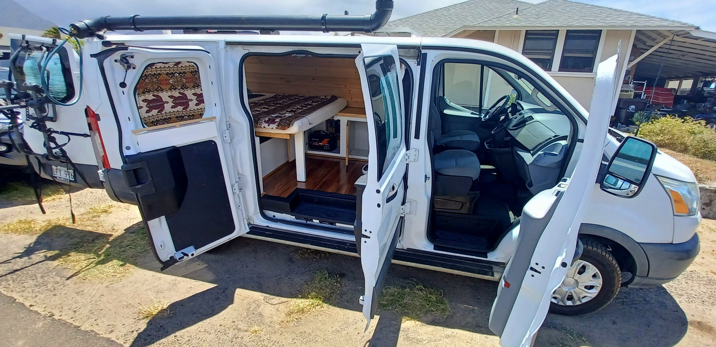 White RV rental camper van with open doors, showcasing a custom wood interior, bed, and front cabin.