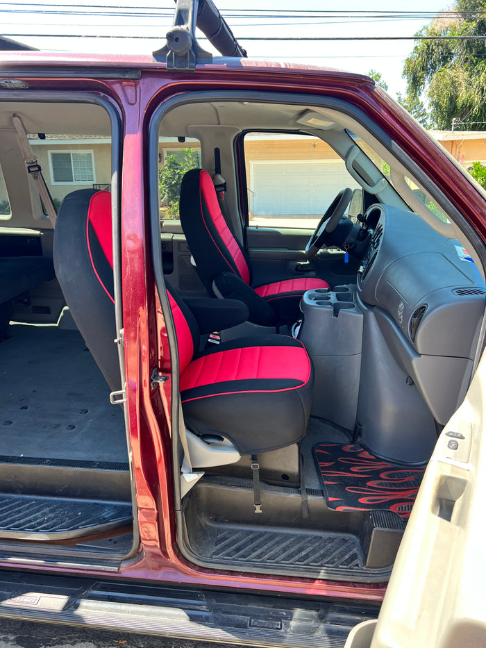 Spacious van interior with red/black seats, ideal for rv rental adventures. Open side door reveals dashboard & rear area for travel.