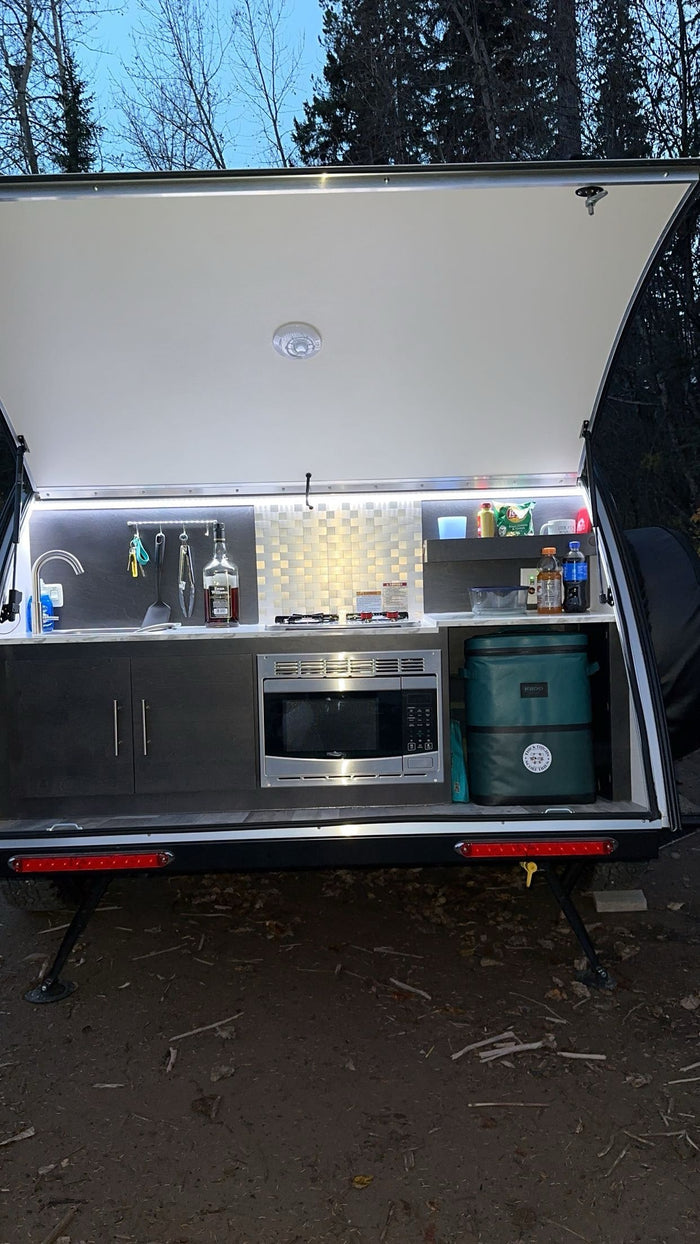 offers cozy outdoor adventure.|Two Dalmatians relax inside an RV rental