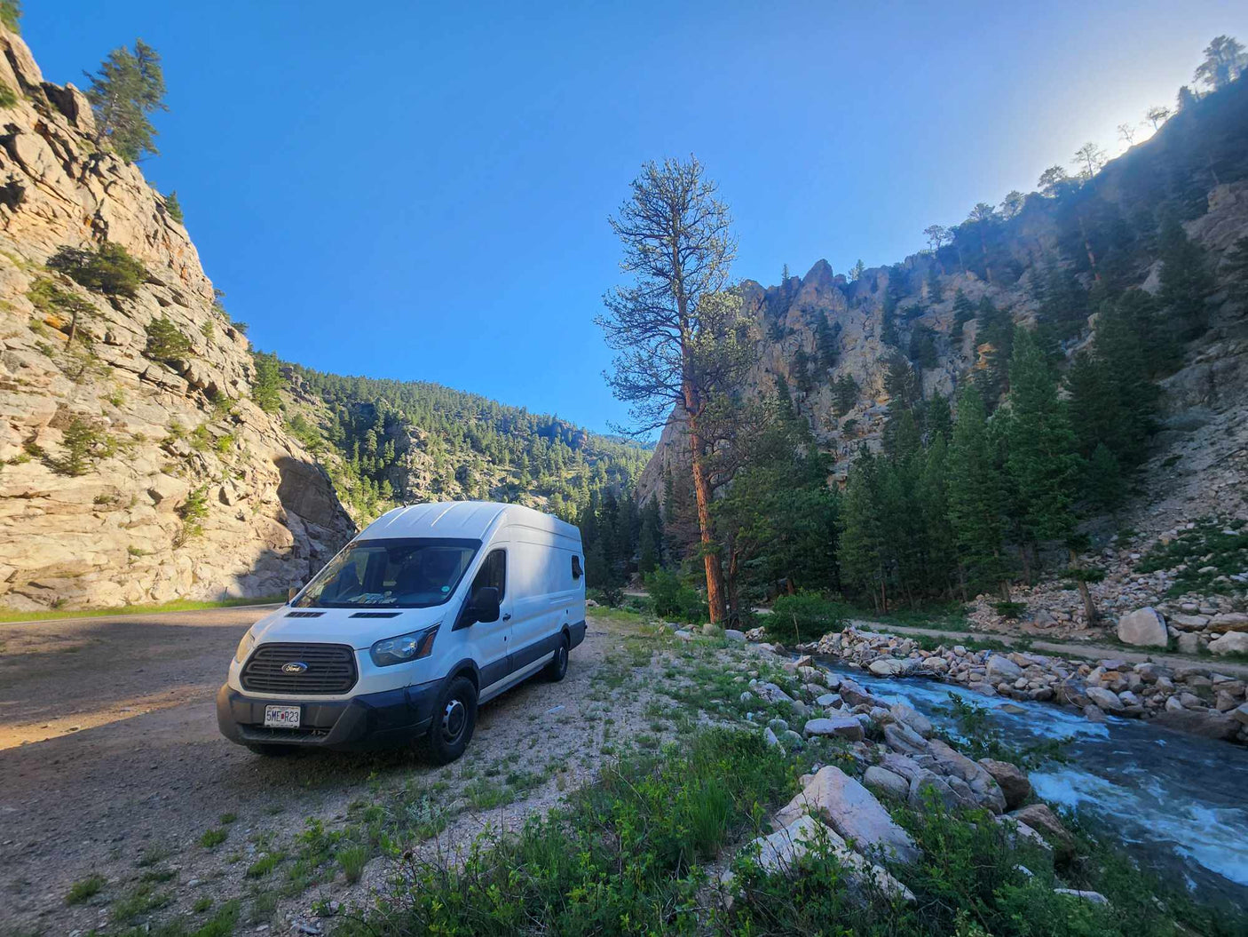 with a crescent moon above.|RV rental with a warm wooden interior. Features a compact kitchen with sink