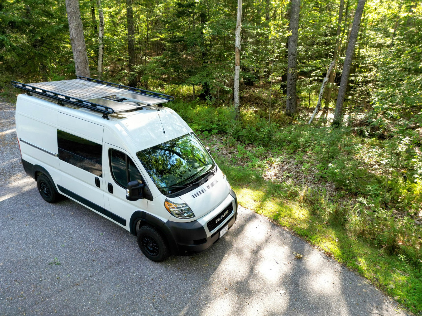 and dining table set with swivel front seats.|Cozy RV rental interior with a made bed