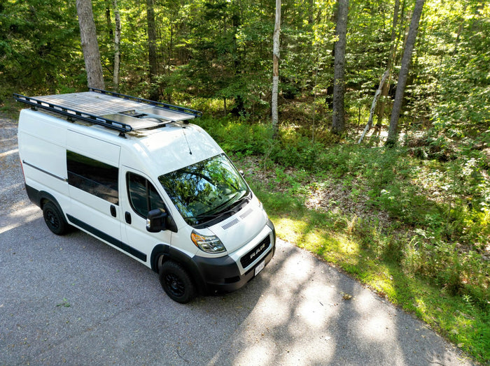 and dining table set with swivel front seats.|Cozy RV rental interior with a made bed