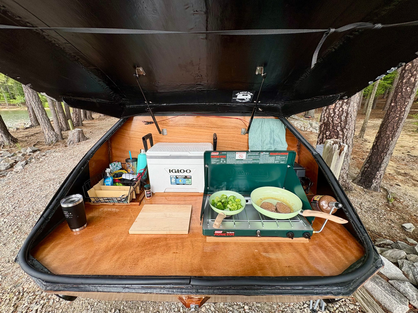 cooking broccoli and burgers on a propane stove by the lake.|Cozy rainy day view from an RV rental window