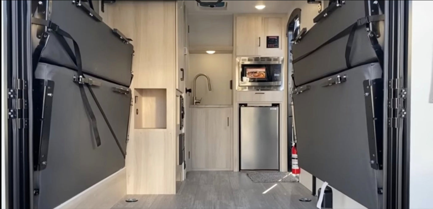 RV rental interior: versatile space with fold-away bunk beds, kitchen (sink, microwave, fridge). Ideal for travel.