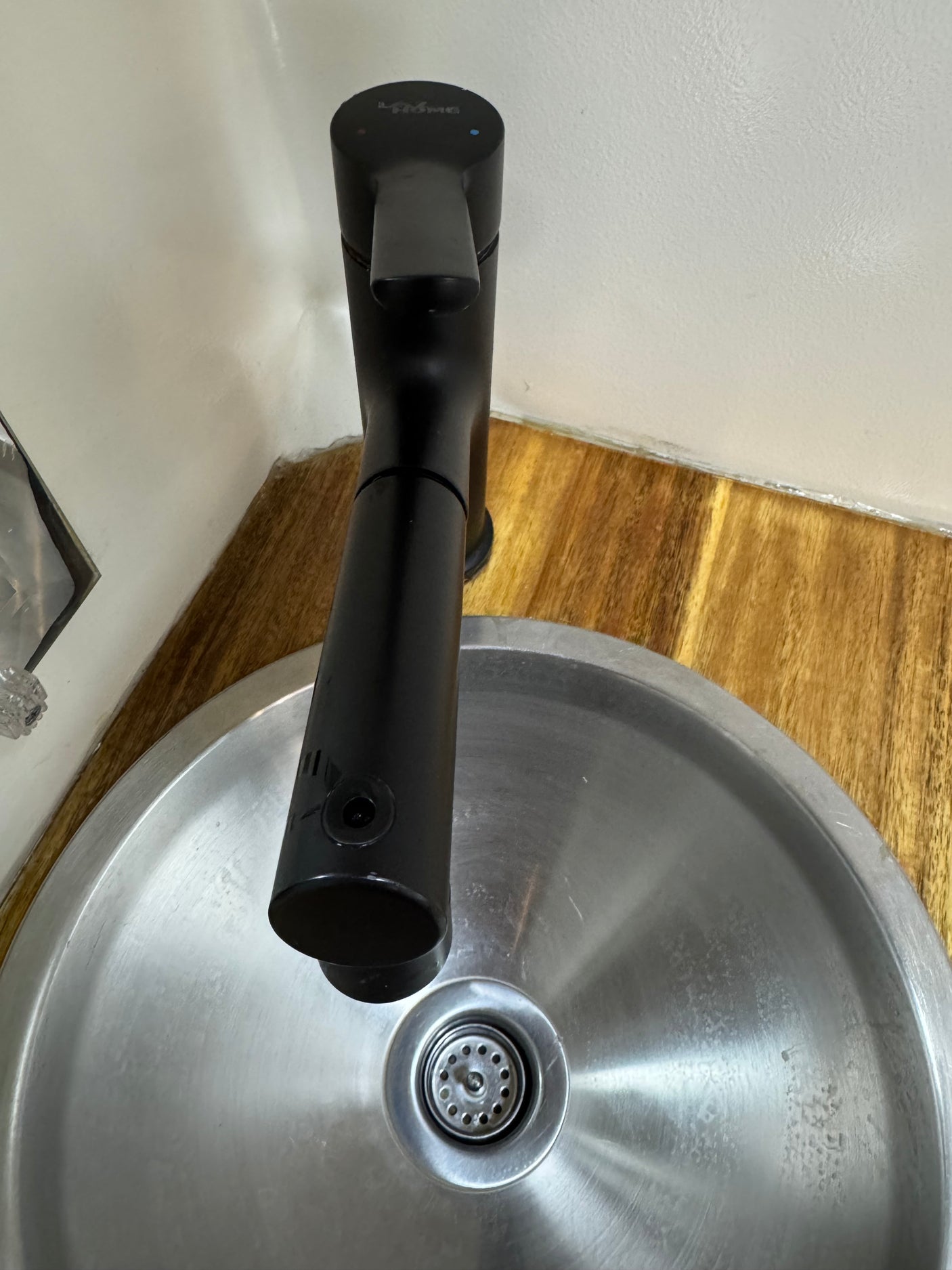 Modern black faucet and round stainless steel sink, set into a wooden counter in an rv rental.