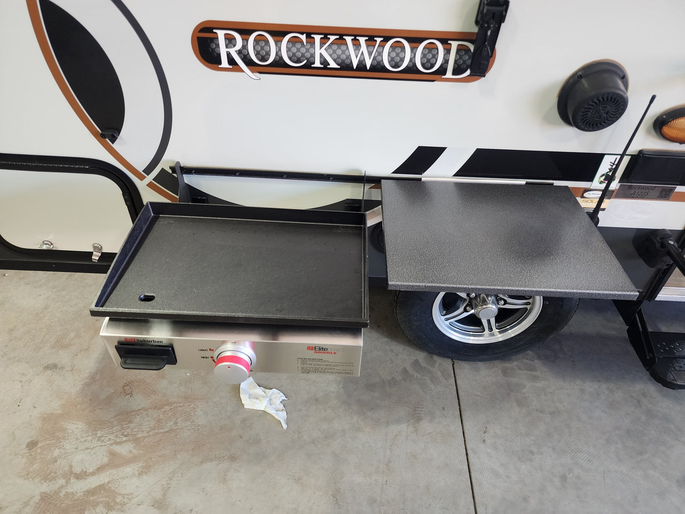 Rockwood RV rental: Outdoor cooking setup featuring a Suburban griddle and side table next to the travel trailer. — photo 2