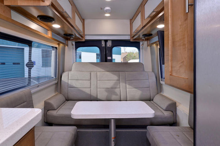 and bench seat define this compact living space.|This gray Ford Transit van is converted into an RV rental