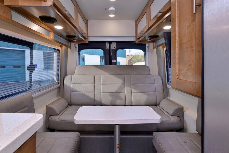 and bench seat define this compact living space.|This gray Ford Transit van is converted into an RV rental