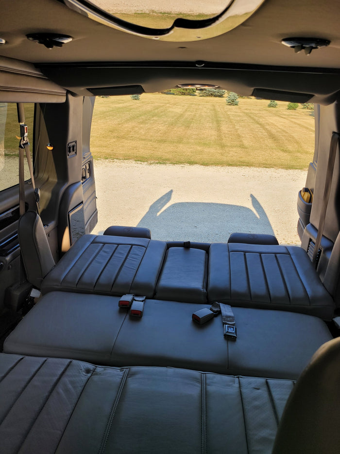 ready for your RV rental adventure.|Explore comfort in this **rv rental**! View of grass/gravel from the interior featuring versatile leather seats converting to a bed.|RV rental: luxurious light leather seating