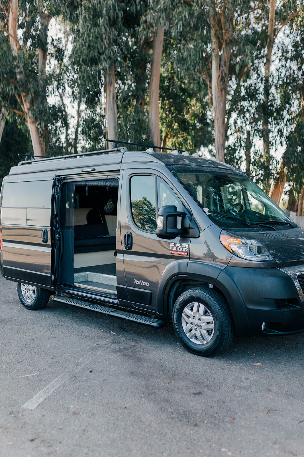 Gray Tofino conversion van, side door open, showing interior. Perfect for your next RV rental road trip.