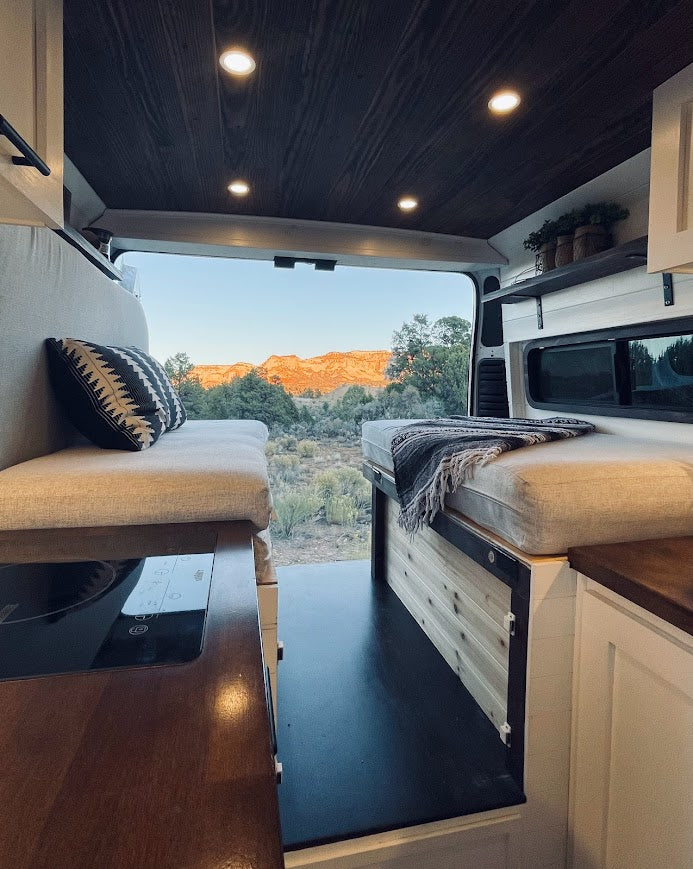 This cozy RV rental provides stunning desert mountain views from its open rear doors for your van life journey.