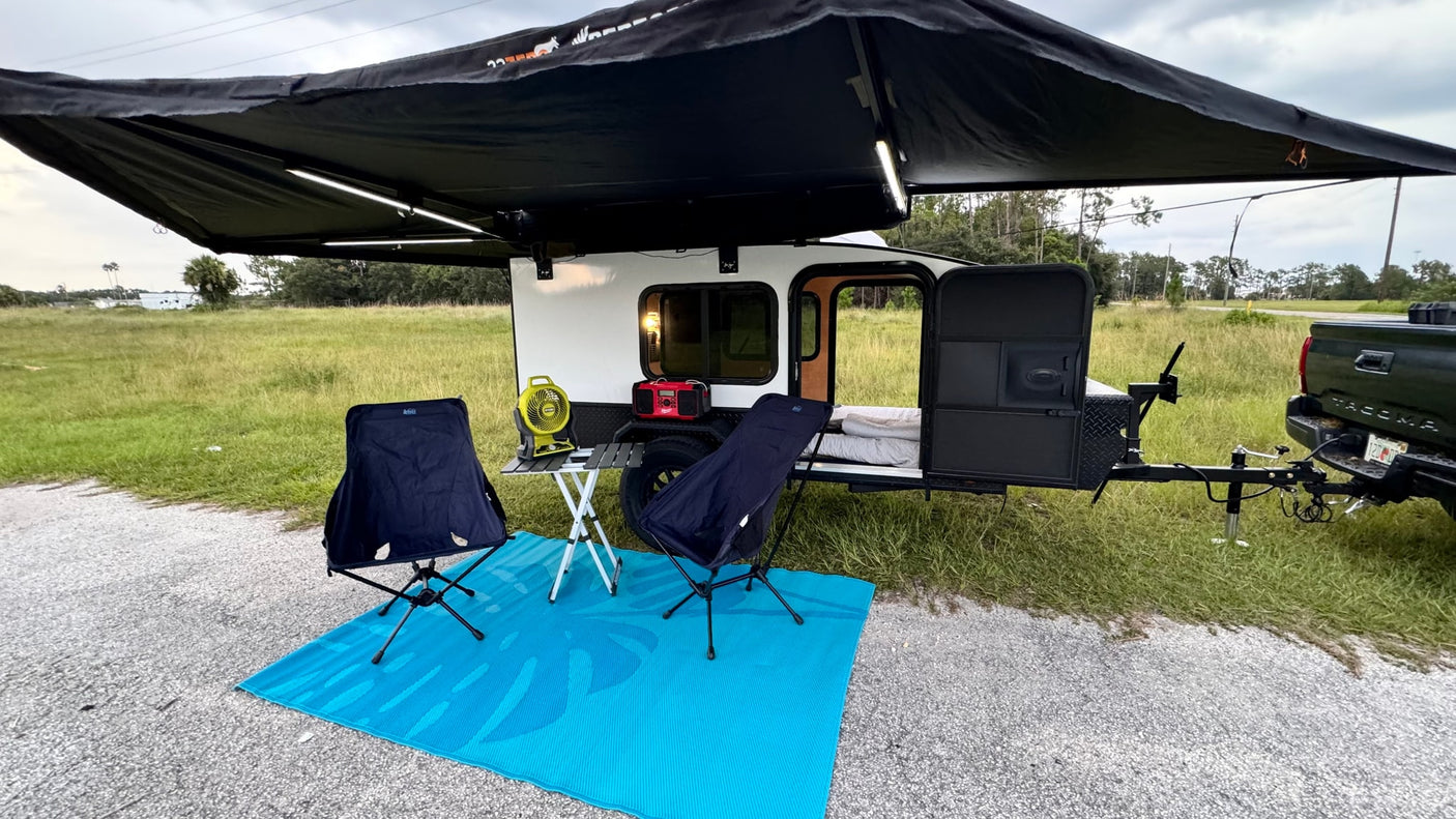 An inviting RV rental setup: a small camper with extended awning