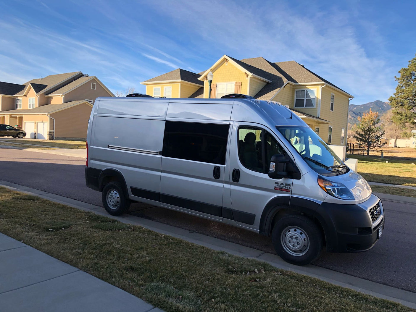 enjoying the view from their camper van.|An RV rental's camper van interior features a modern kitchen